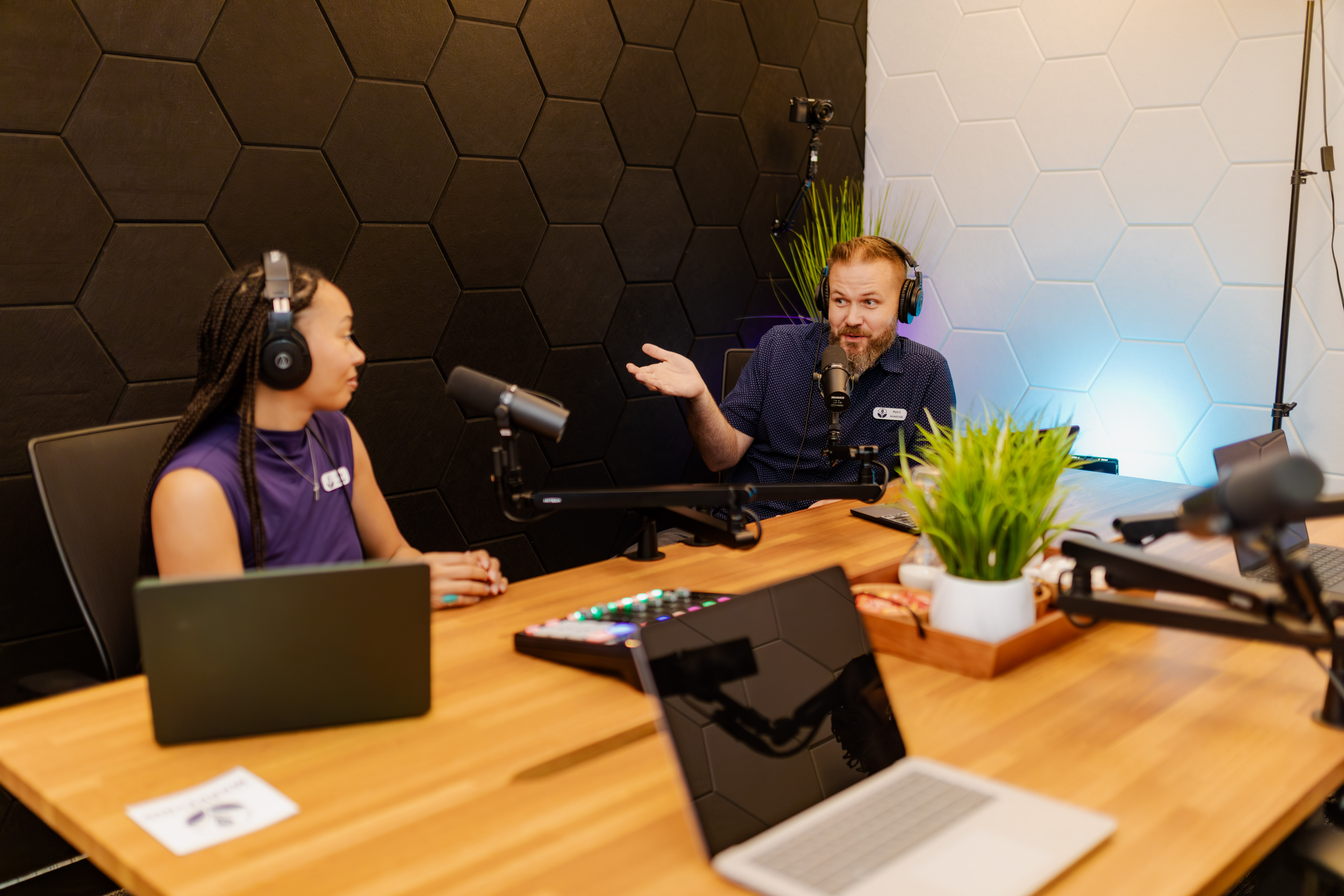 Matt Nelson recording a podcast episode with a Peachtree Rose Marketing team member in the San Antonio studio, a two-person interview setup with microphones, headphones, and acoustic panels.