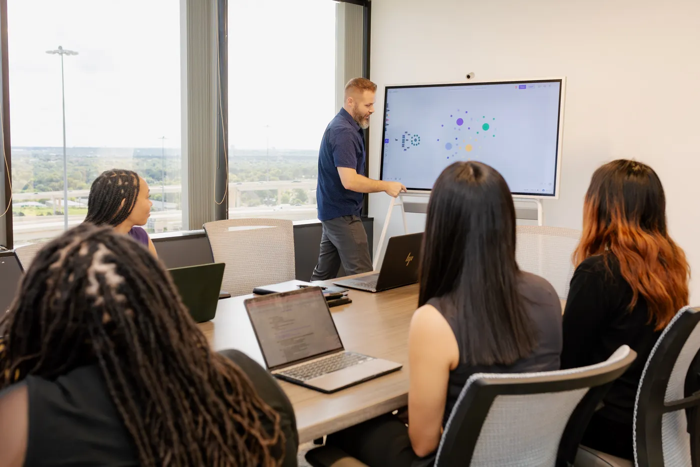 The Peachtree Rose Marketing team reviews a strategy map on a large screen during a working session.